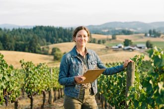 Femme dans un vignoble en tenue casual souriante